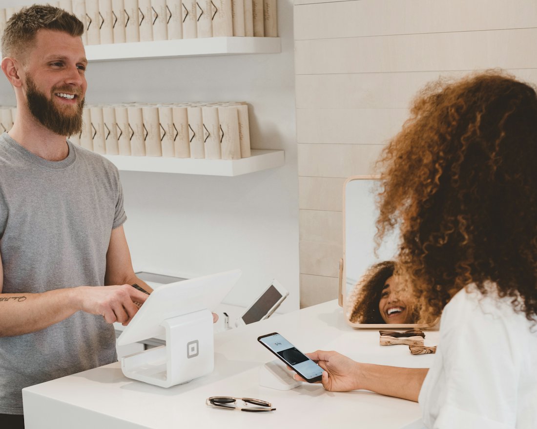 Small business owner serving a customer at the counter